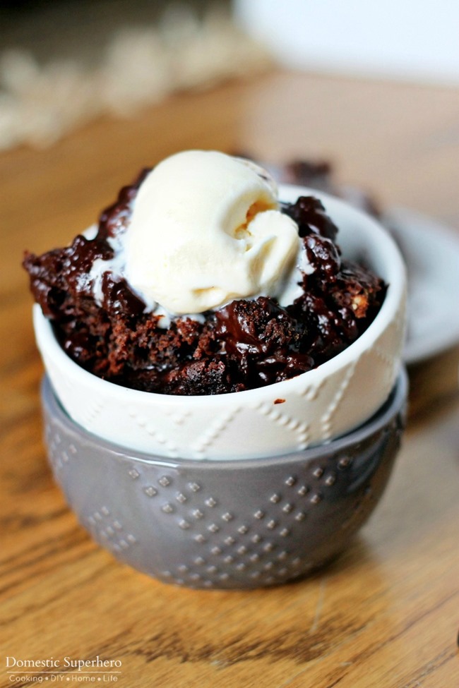 Slow Cooker Chocolate Lava Cake – Domestic Superhero in a white bowl stacked inside a grey bowl on a wood surface