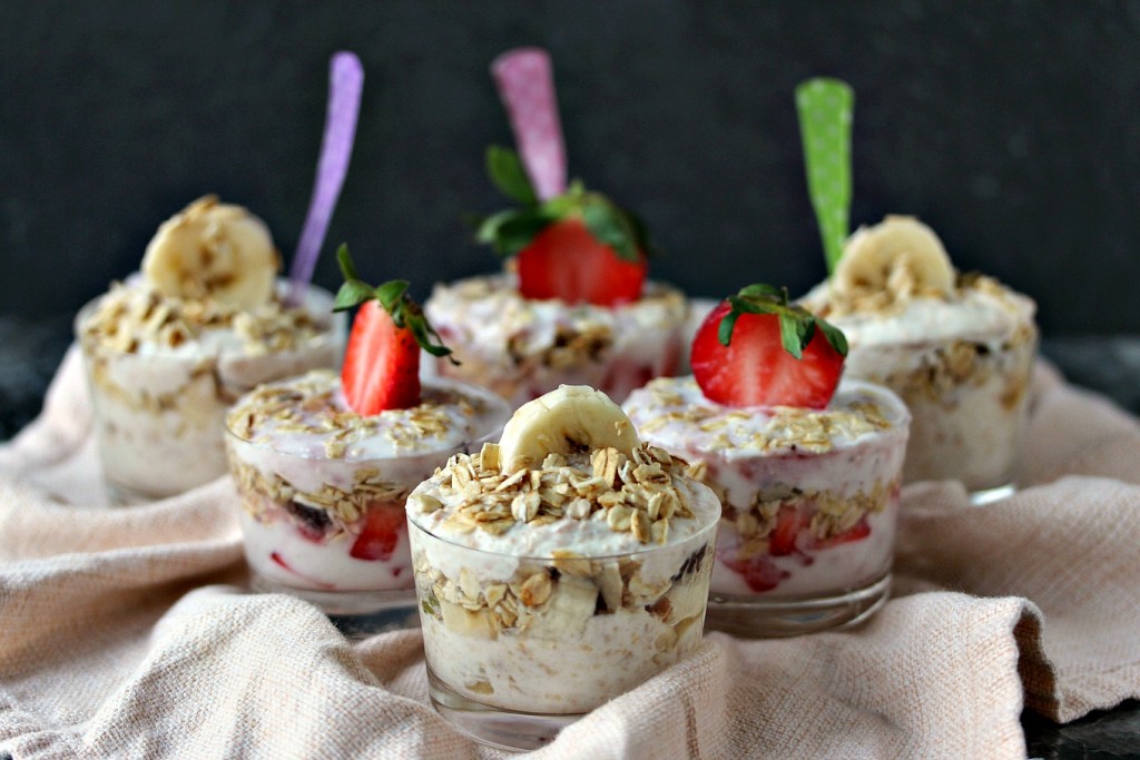 Yogurt Parfaits in tiny glasses with colourful spoons in each