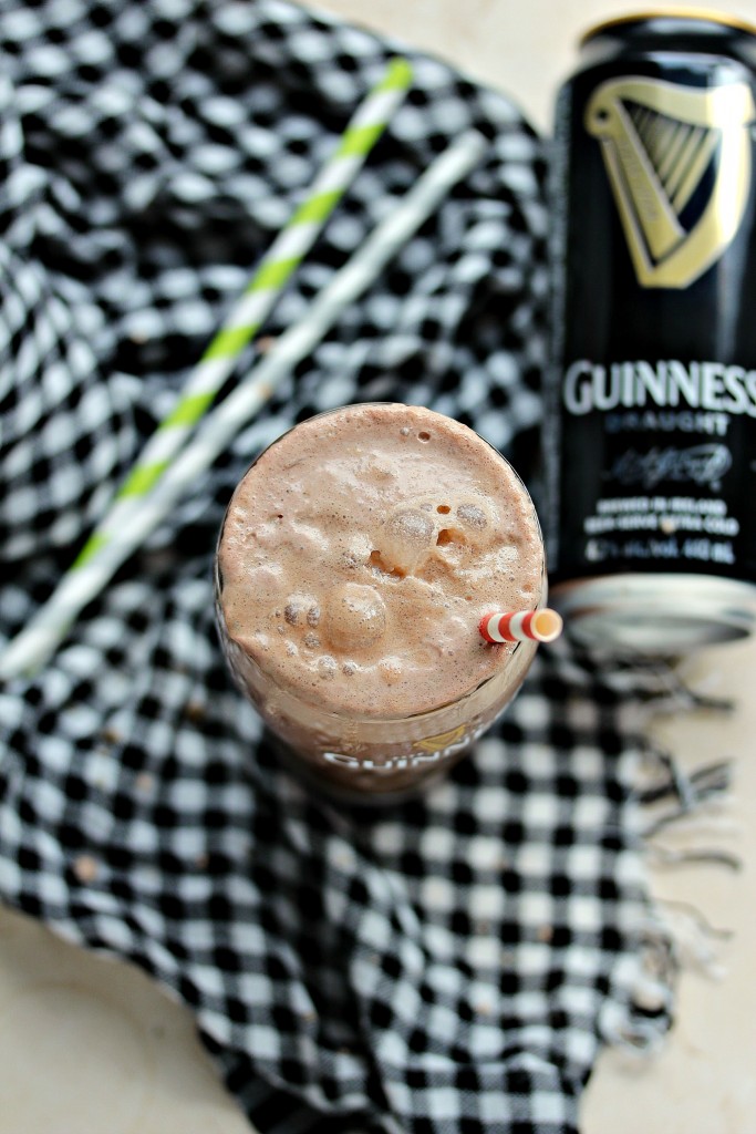 Chocolate Guinness float overhead image of glass, beer can, straws, all set on a houndstooth fabric napkin.