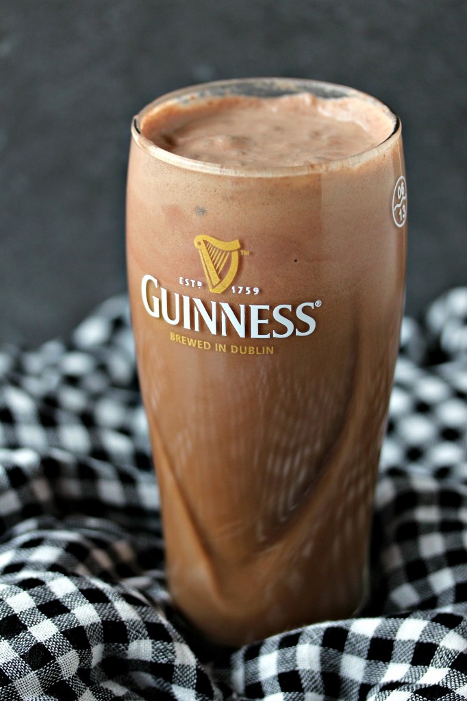Chocolate Guinness float in a tall glass set on a houndstooth fabric napkin. 