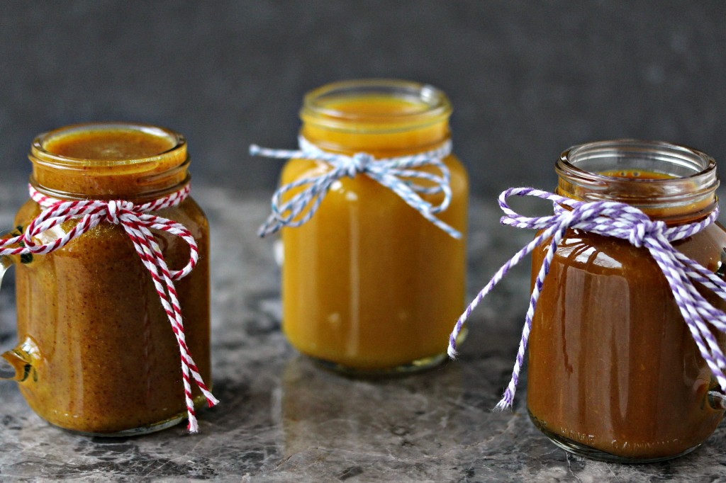 Mustard dipping sauces served in tiny mason jars with twine tied around the top of each of the three glasses.
