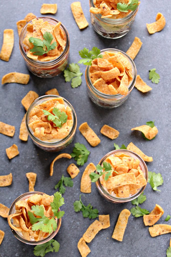 overhead image of individual Mini Fritos Taco Salads layered in mason jars 