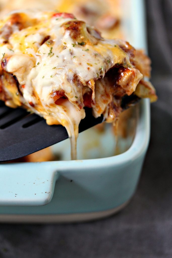 Chicken Enchilada Casserole in a serving dish with a slice being lifted out