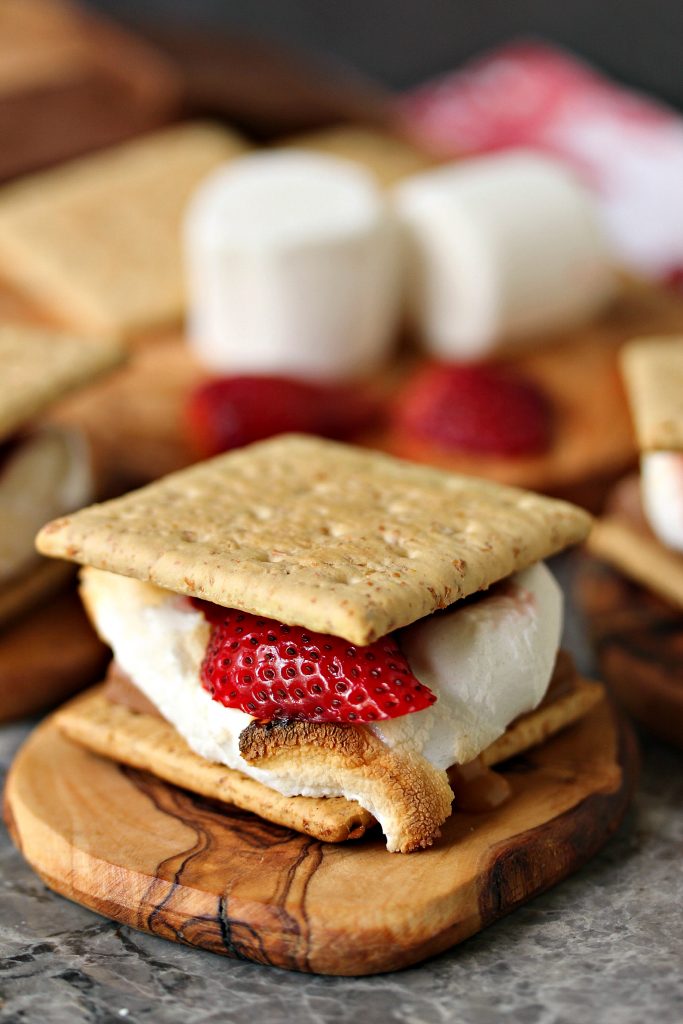 Grilled Strawberry and Caramel S'mores served on wooden coasters.