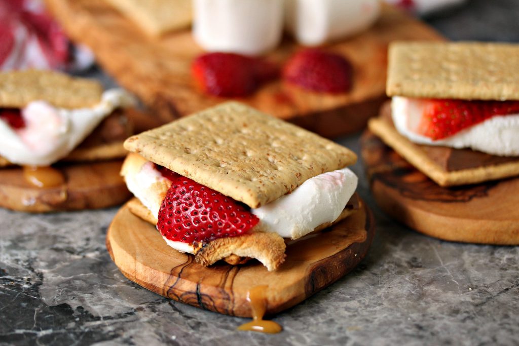 Grilled strawberry caramel s'mores served on wooden coasters.