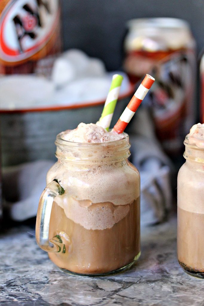Chocolate Hot Fudge Root Beer Float in a mason jar with a bucket of root beer behind it. 