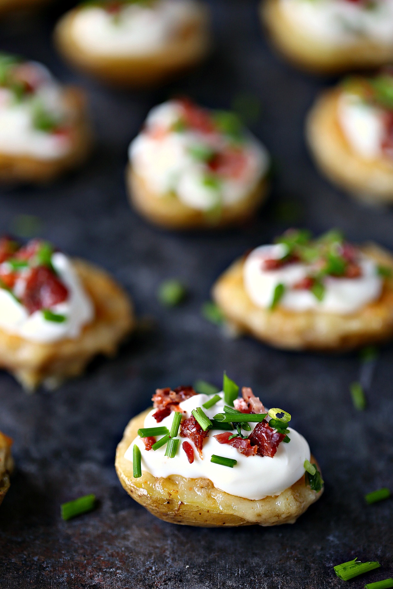 Mini Potato Skins with Sour Cream, Bacon, and Chives from cravingsofalunatic.com- This recipe for Mini Potato Skins with Sour Cream, Bacon, and Chives is simple and delicious. These little bites are perfect for entertaining, especially during game season.