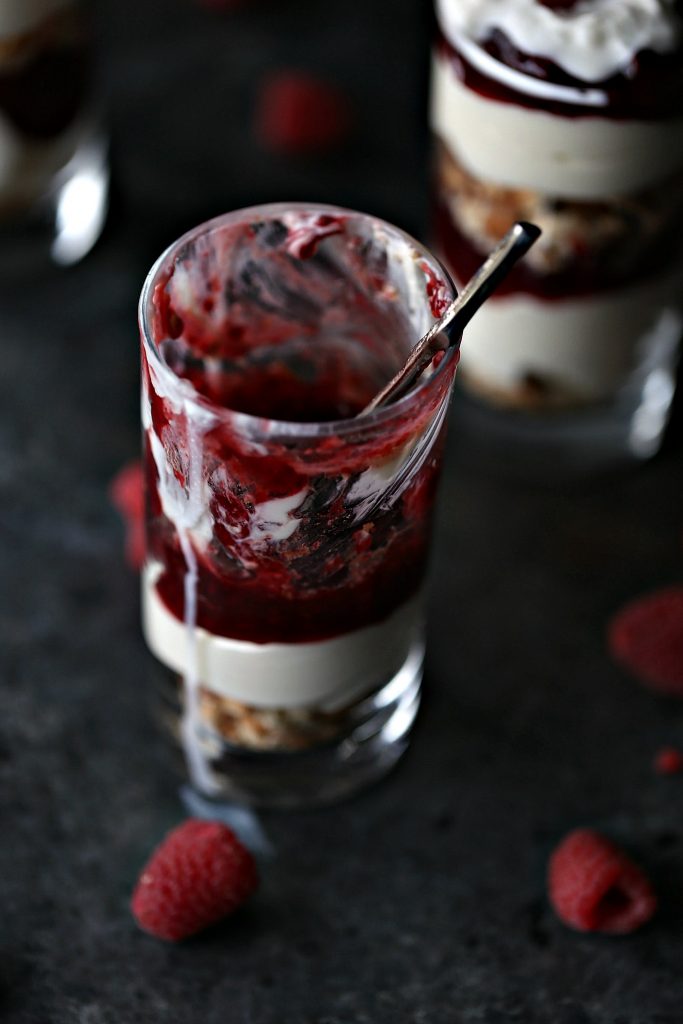 No Bake Lemon Raspberry Cheesecake Parfaits served in tiny dessert glasses with silver spoons.