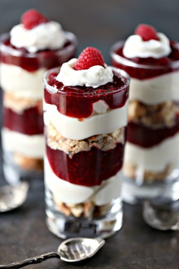No Bake Lemon Raspberry Cheesecake Parfaits served in mini glasses and are layered and topped with a fresh raspberry