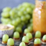Green grapes dipped in melted caramel and graham crumbs.