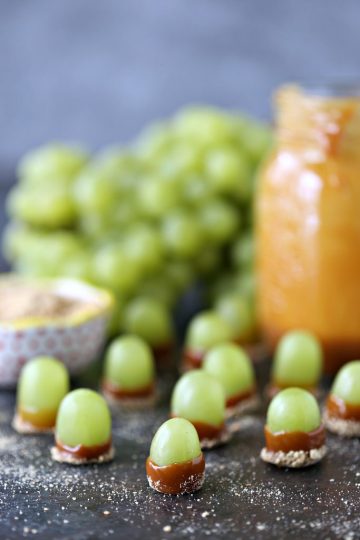 Green grapes dipped in melted caramel and graham crumbs.