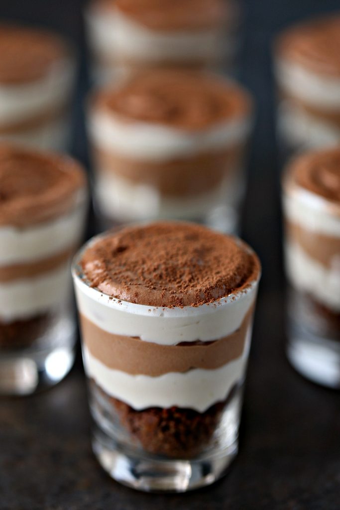 No-Bake Chocolate and Coffee Mini Cheesecakes in small shot glasses on a dark table 
