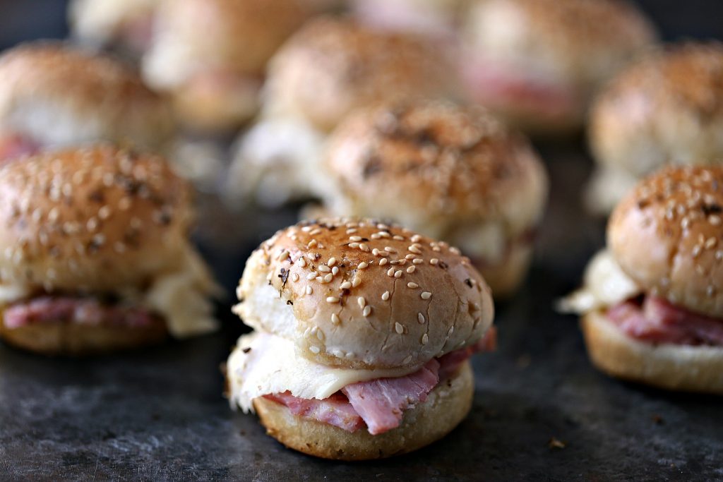 Ham and cheese sliders on a dark counter. 