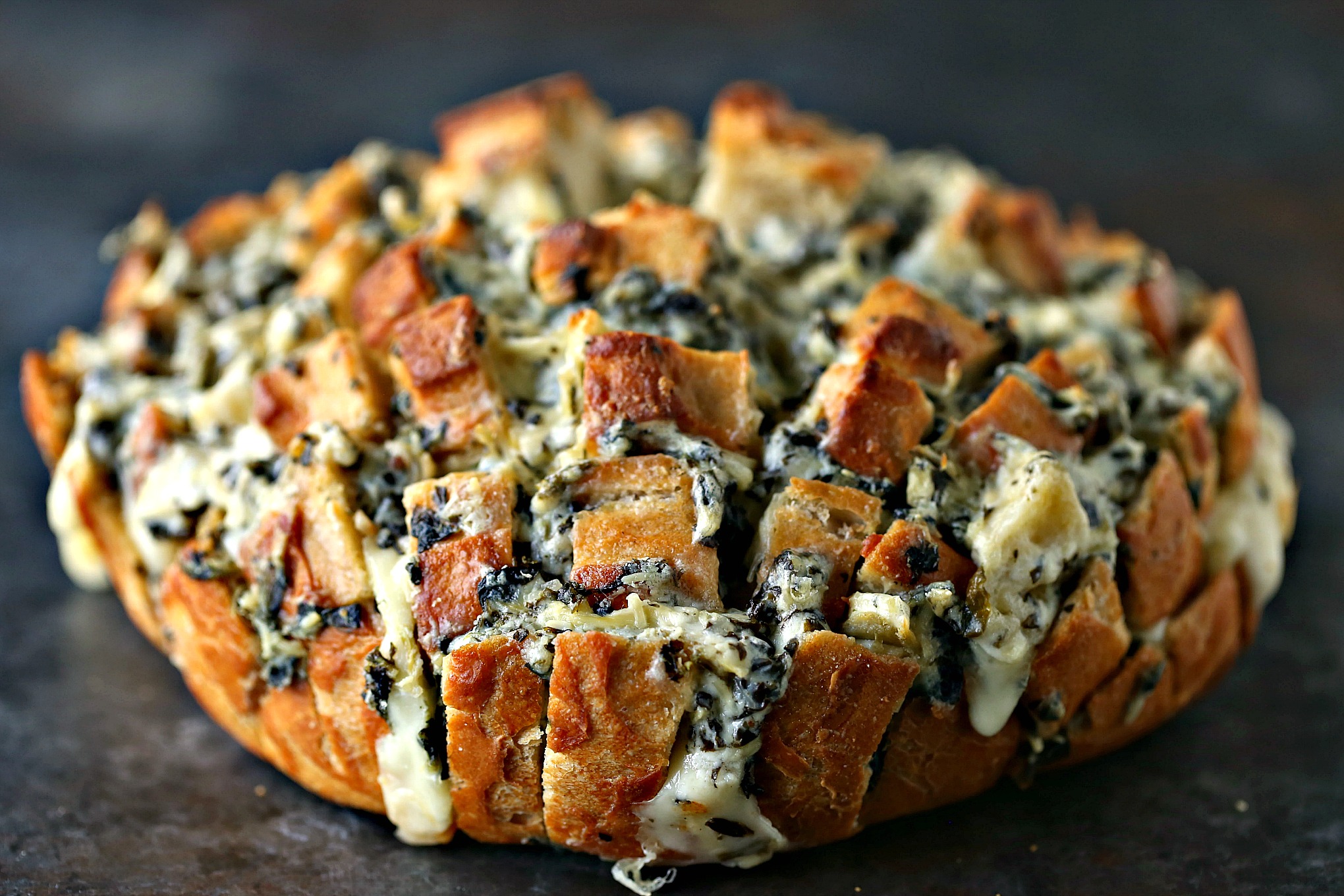 Spinach-Artichoke Cheesy Bread from cravingsofalunatic.com- This recipe is chock full of flavor yet remarkably easy to make. The bread is stuffed with spinach artichoke dip and cheese. You need to make this bread immediately. 