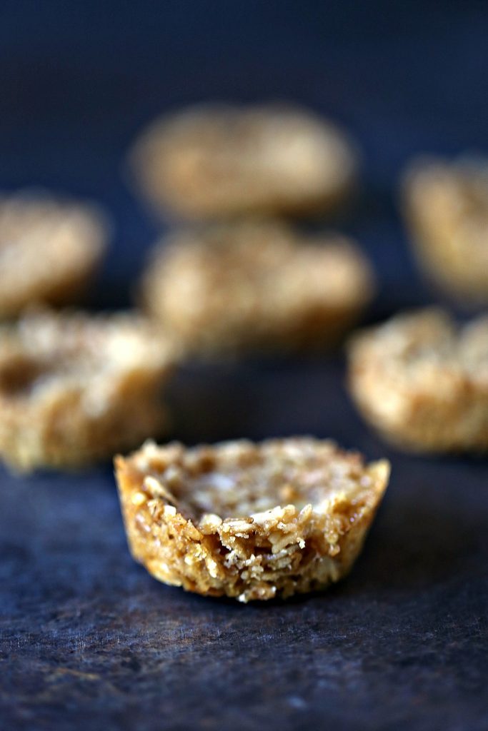 Granola cups removed from pan and sitting on a dark counter.