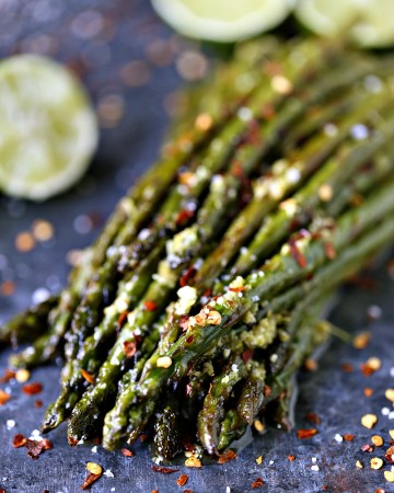 Skillet Asparagus with Lime Butter on a grey counter with limes in the background.