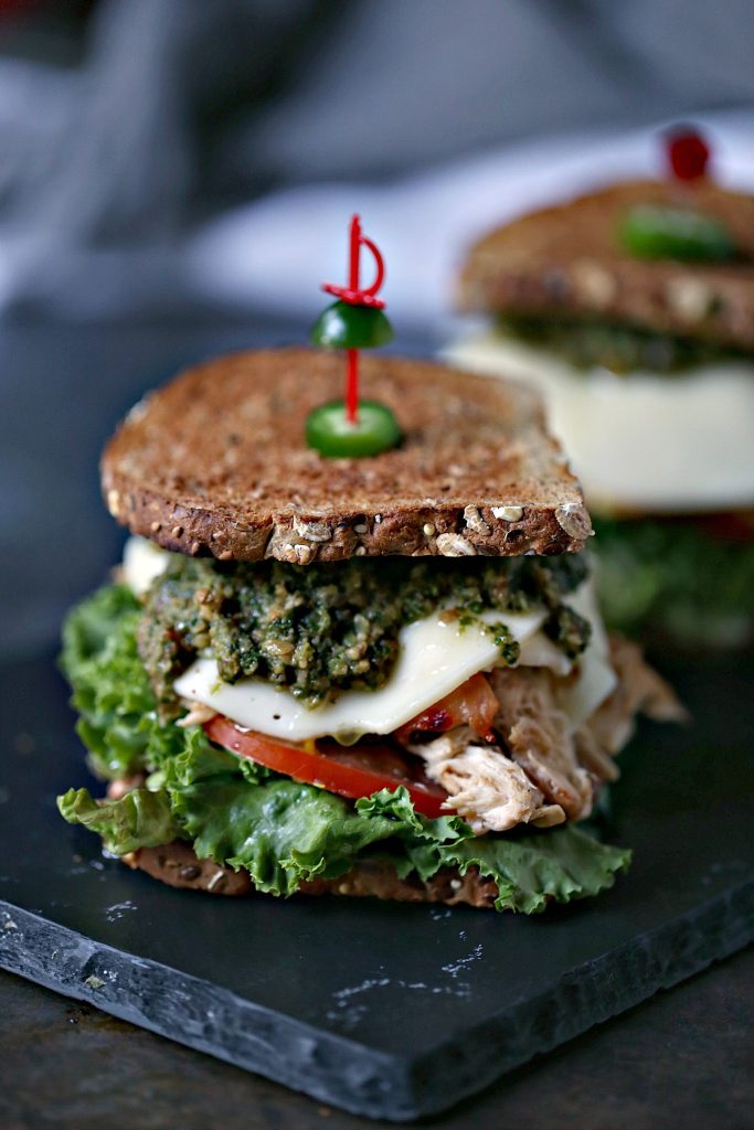 Grilled Chicken Sandwich with Basil Pesto is an easy recipe that will delight your tastebuds. It's piled high with vegetables, chicken, cheese, and pesto.