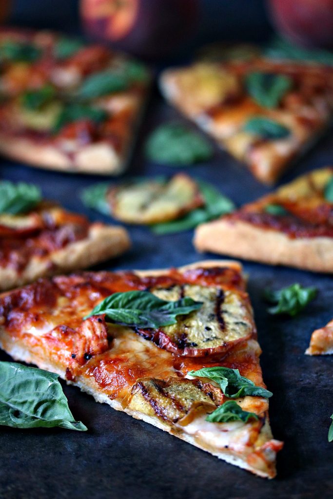 grilled peach and chicken pizza with fresh basil cut into slices