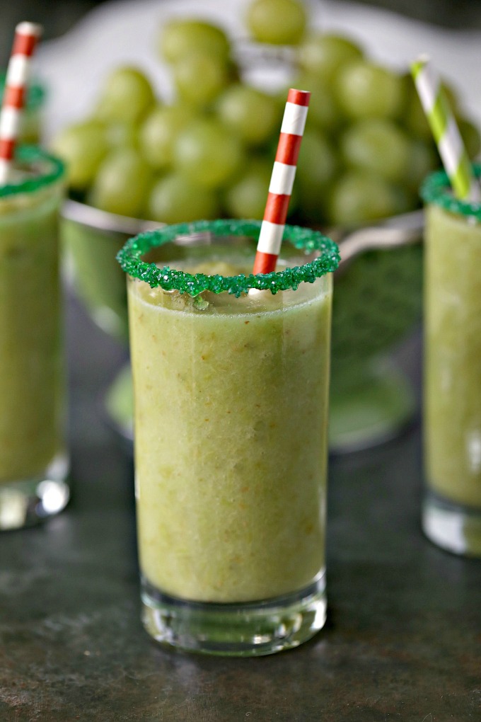 green grape slushies in glasses with sugar rims and a colander filled with green grapes in background 