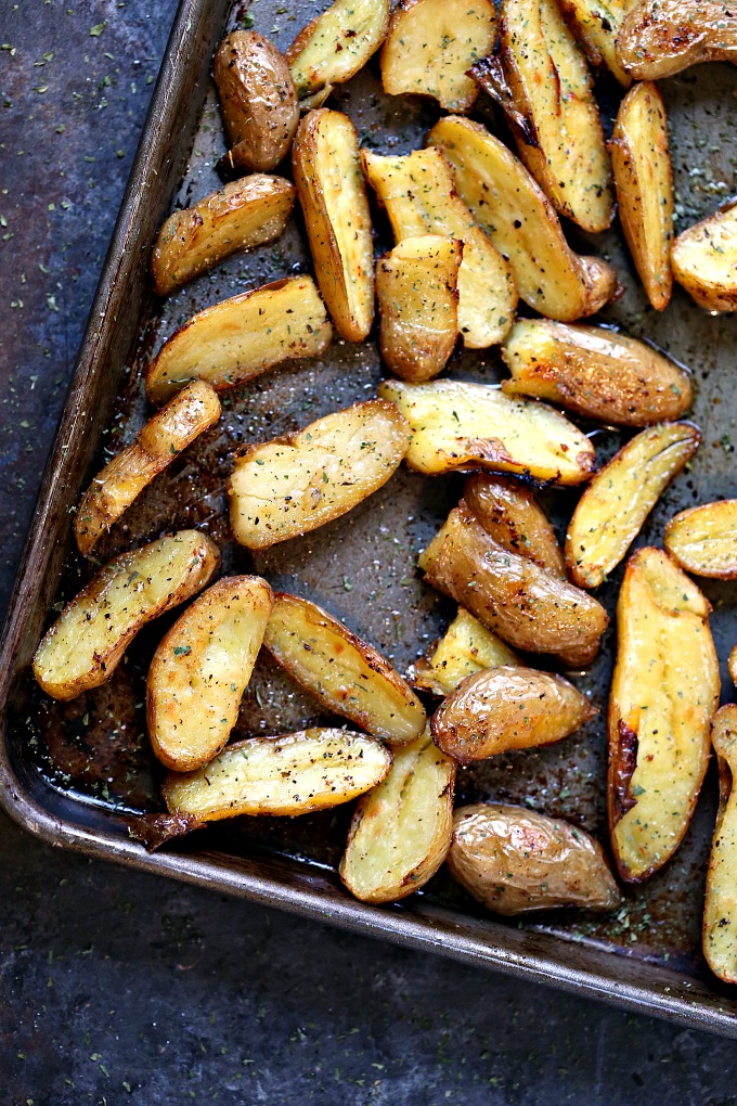 overhead image of lemon roasted fingerling potatoes cooked on a sheet pan on a counter