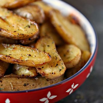 roasted lemon roasted fingerling potatoes served in a red bowl