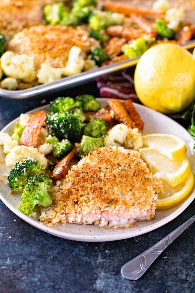 close up image of Sheet Pan Lemon Parmesan Crusted Salmon and Vegetables from Julie's Eats and Treats served on a white plate with pan in background