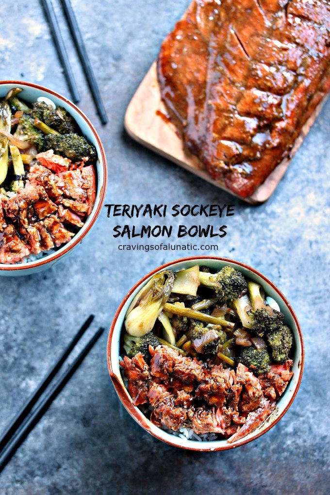 overhead image of Teriyaki Sockeye Salmon Bowls from Cravings of a Lunatic in stir fry bowls with a piece of salmon on a wood plank