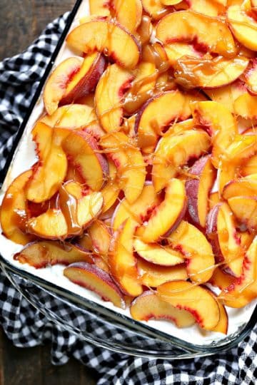 Overhead image of a peach icebox cake drizzled with caramel sauce in a clear baking dish