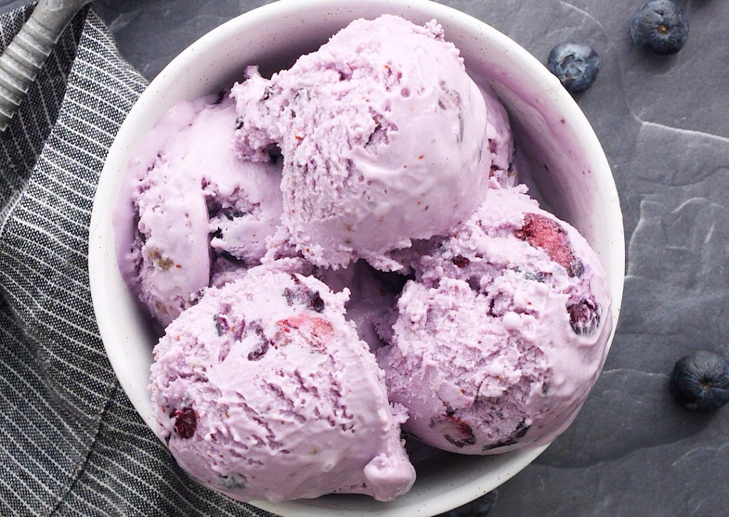Roasted blueberry cheesecake ice cream in a white bowl 
