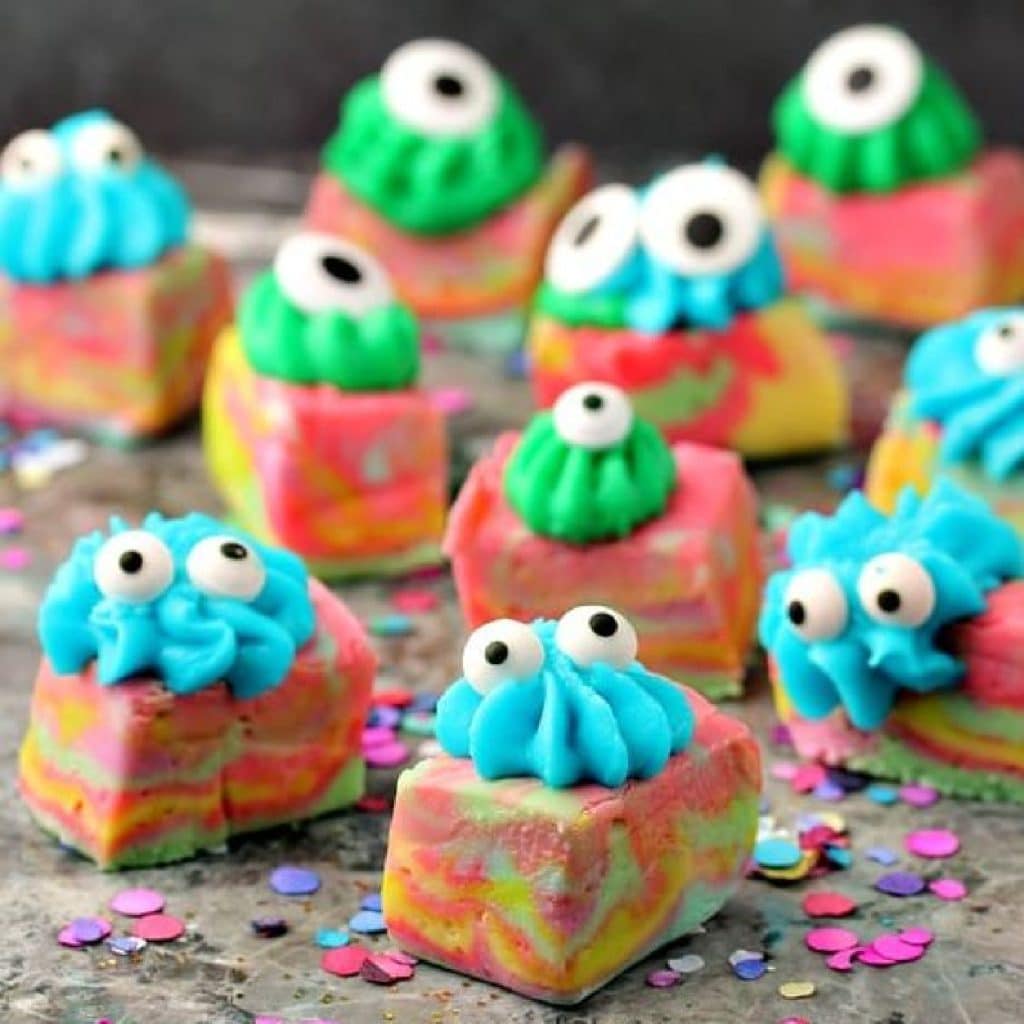 Pieces of brightly coloured swirled fudge topped with icing and googly eyes so they look like little monster.