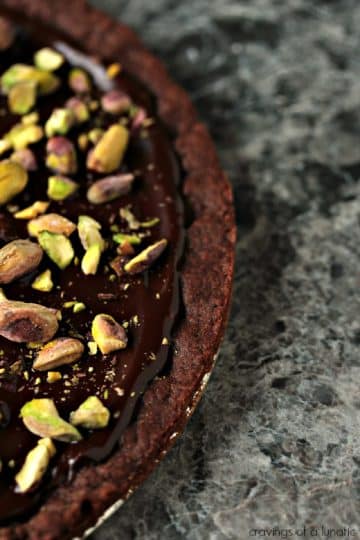 Overhead image of a round batch of chocolate shortbread with pistachios.