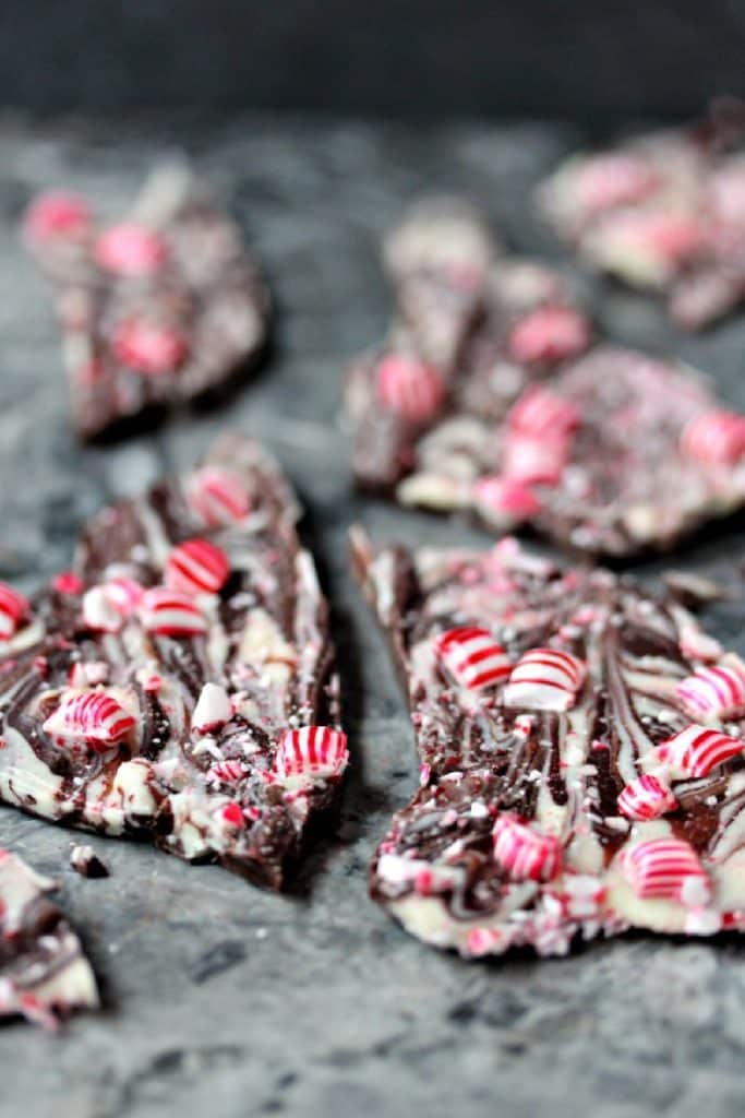 Pieces of chocolate peppermint bark on a grey marble counter.