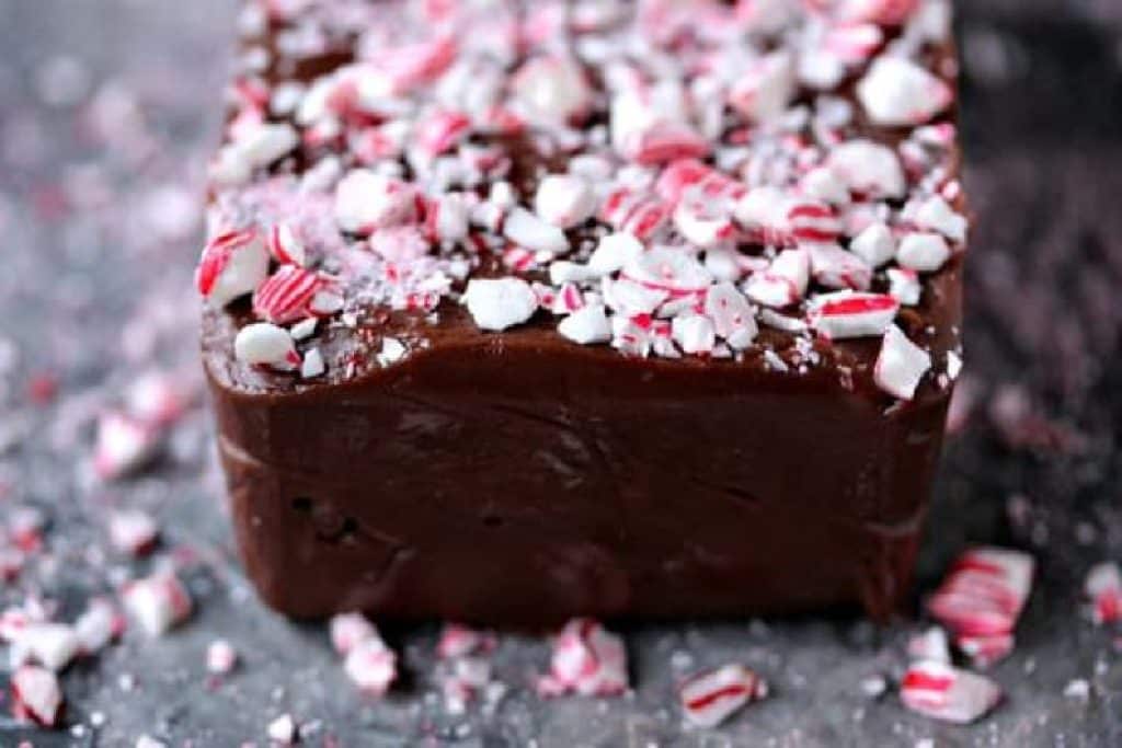 A close up photo of a slab of chocolate peppermint fudge on a grey marble counter. 