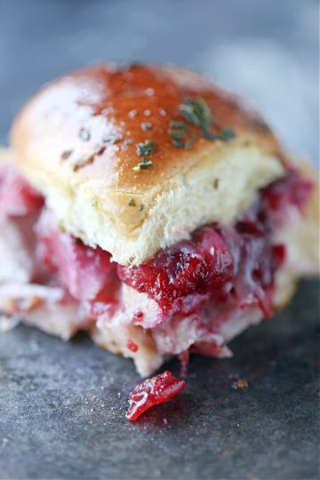 Close up image of a turkey cranberry slider on a dark counter.