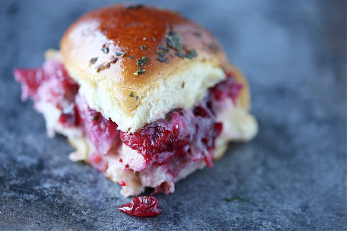 Close up image of a turkey cranberry slider on a dark counter.