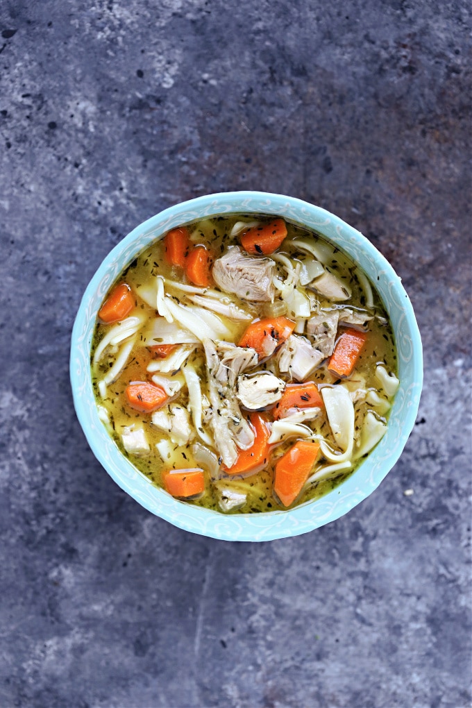 Overhead image of turkey soup in a blue bowl.
