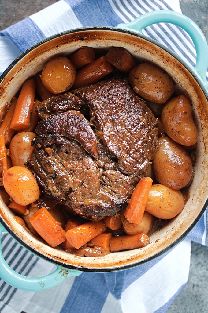 Overhead image of pot roast and veggies in a dutch oven.